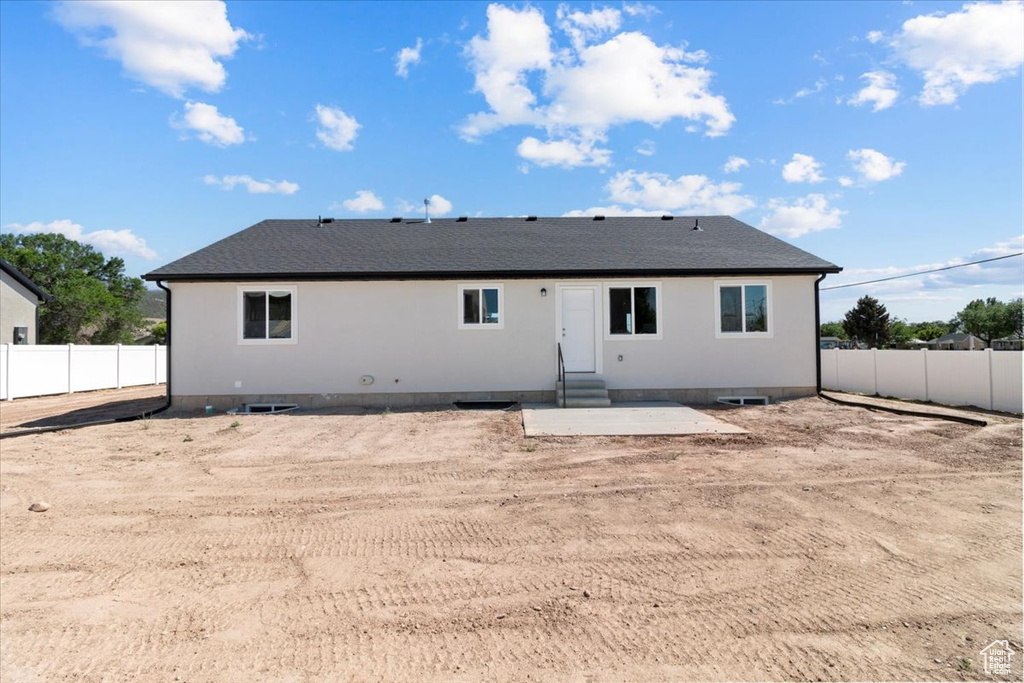 Rear view of house with a fenced backyard, a patio, and entry steps