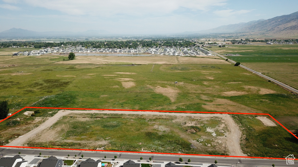 Aerial view of property and surrounding area featuring a mountainous background and property boundaries highlighted
