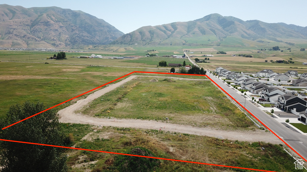Overview of rural landscape with property boundaries highlighted and a mountainous background