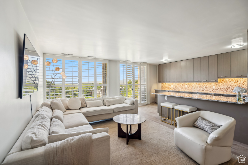 Living area with light wood-style floors and a wall of windows