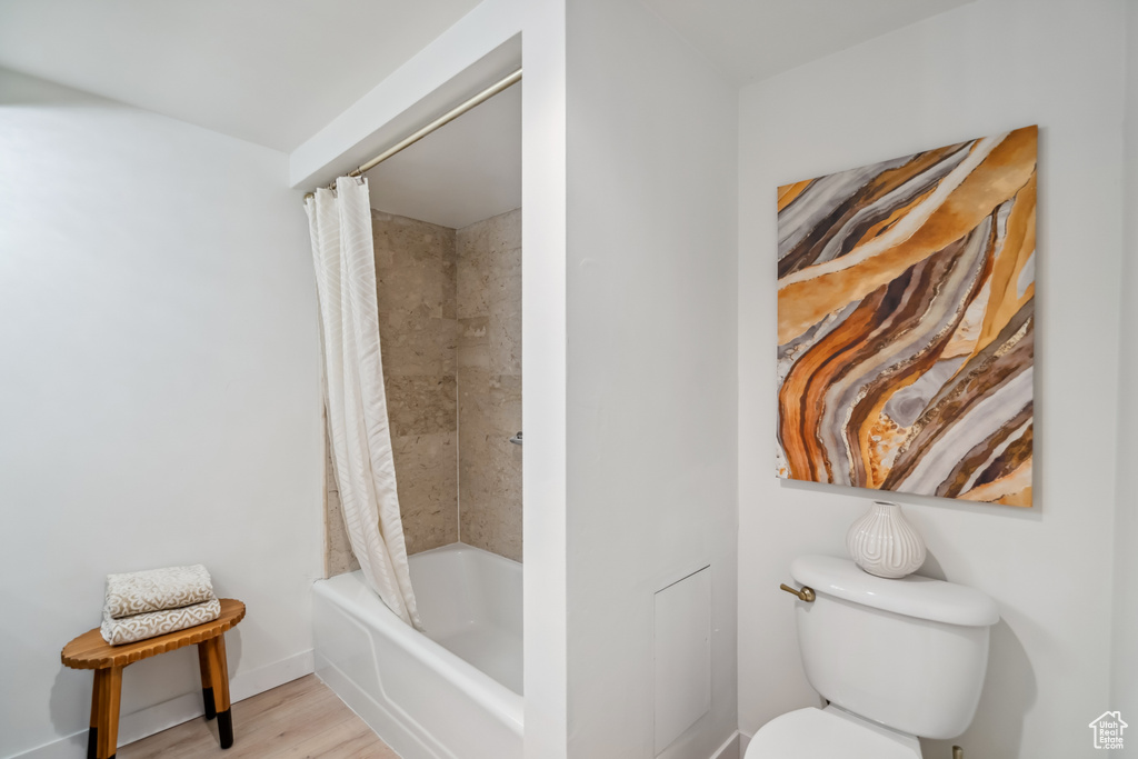 Full bathroom with shower / bathtub combination with curtain and wood finished floors