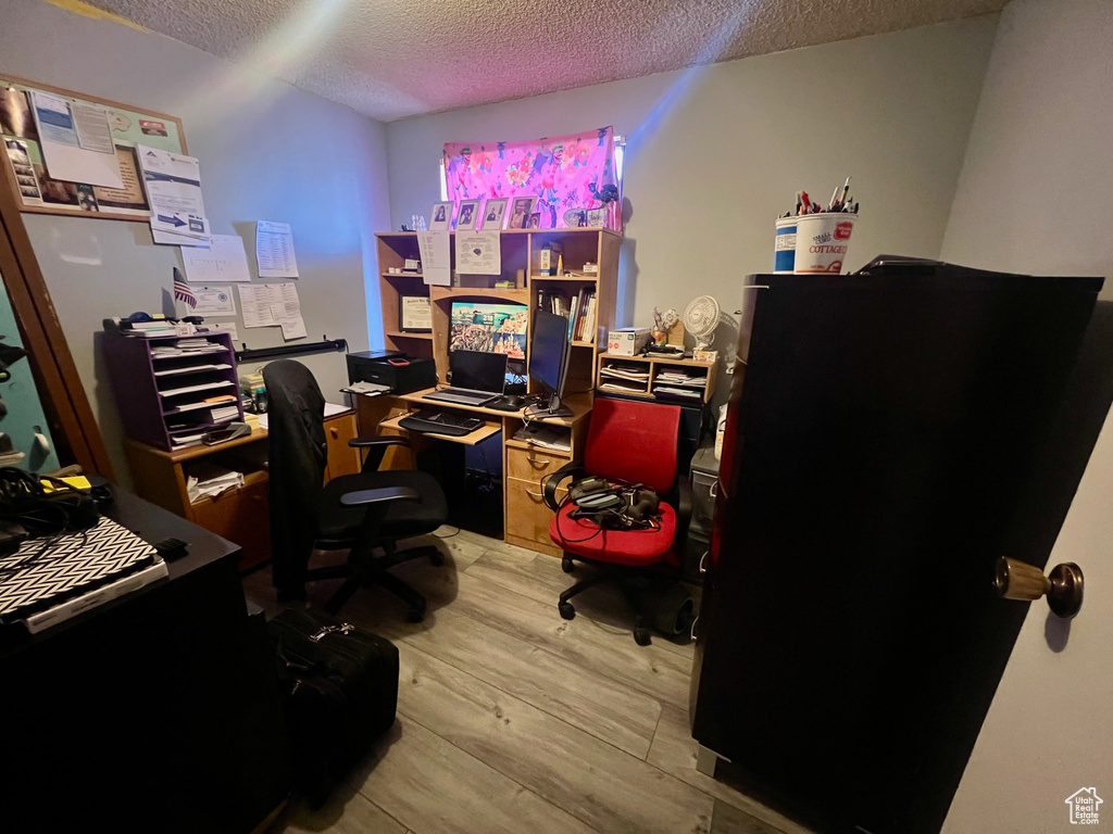 Office with a textured ceiling and wood finished floors
