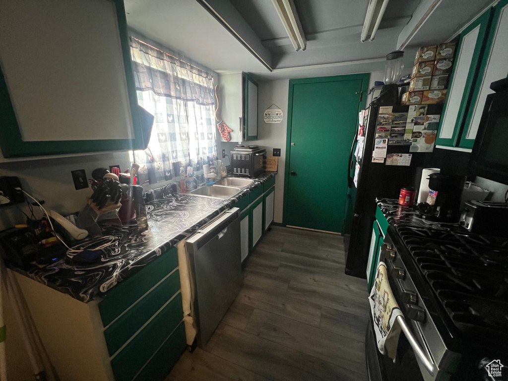 Kitchen featuring appliances with stainless steel finishes and wood finished floors