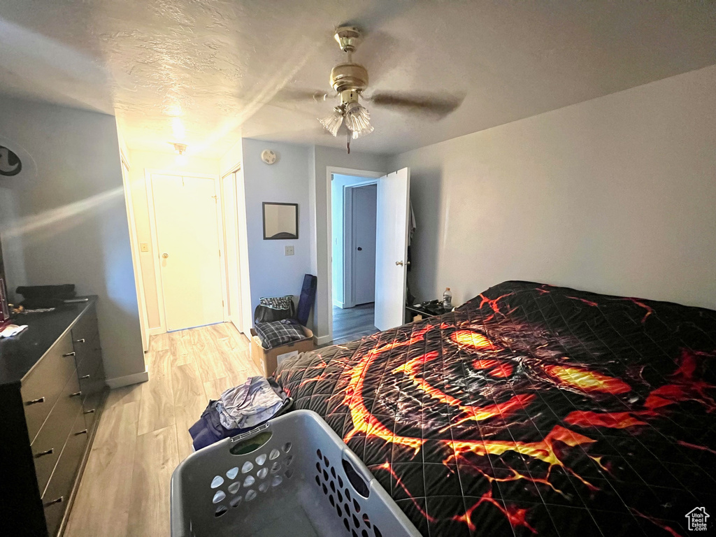 Bedroom with light wood finished floors and a ceiling fan