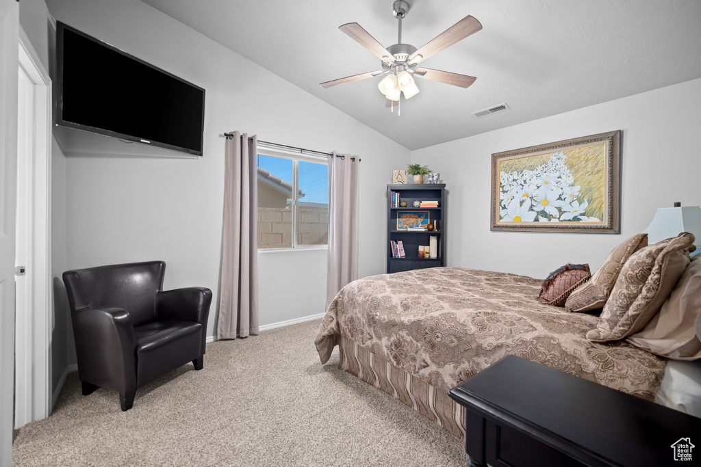 Bedroom with lofted ceiling, light carpet, and a ceiling fan
