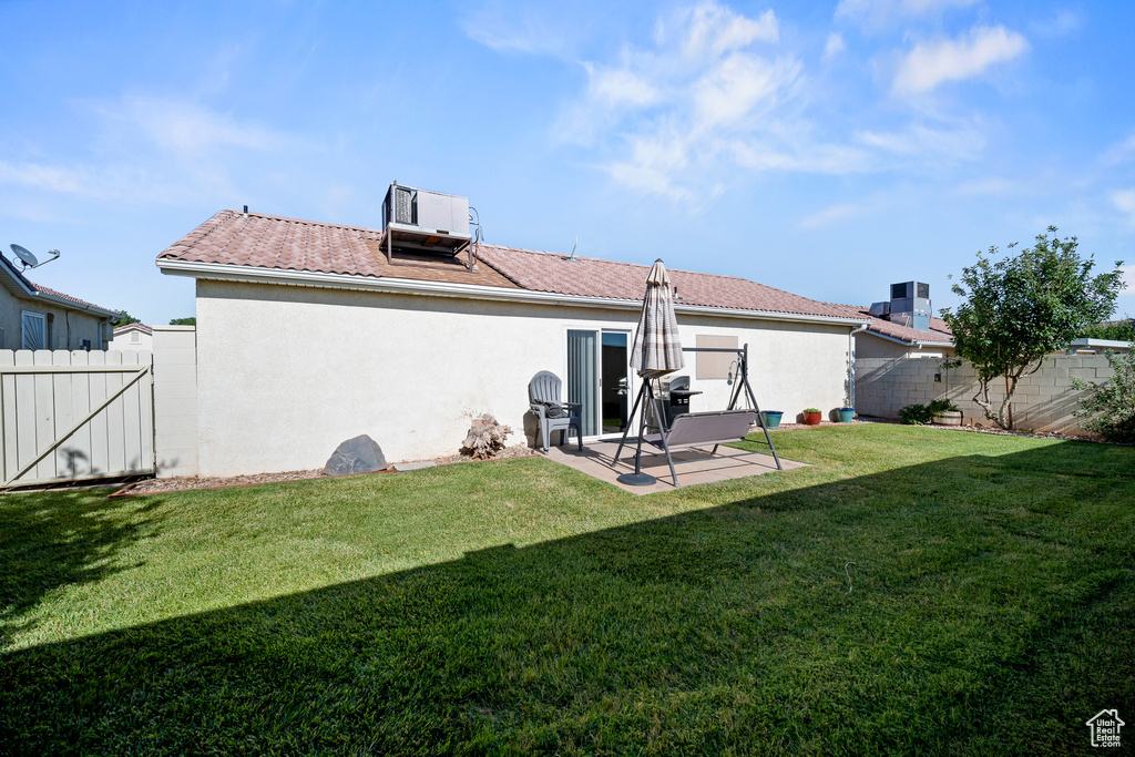 Back of property with a patio area, a fenced backyard, stucco siding, and a gate