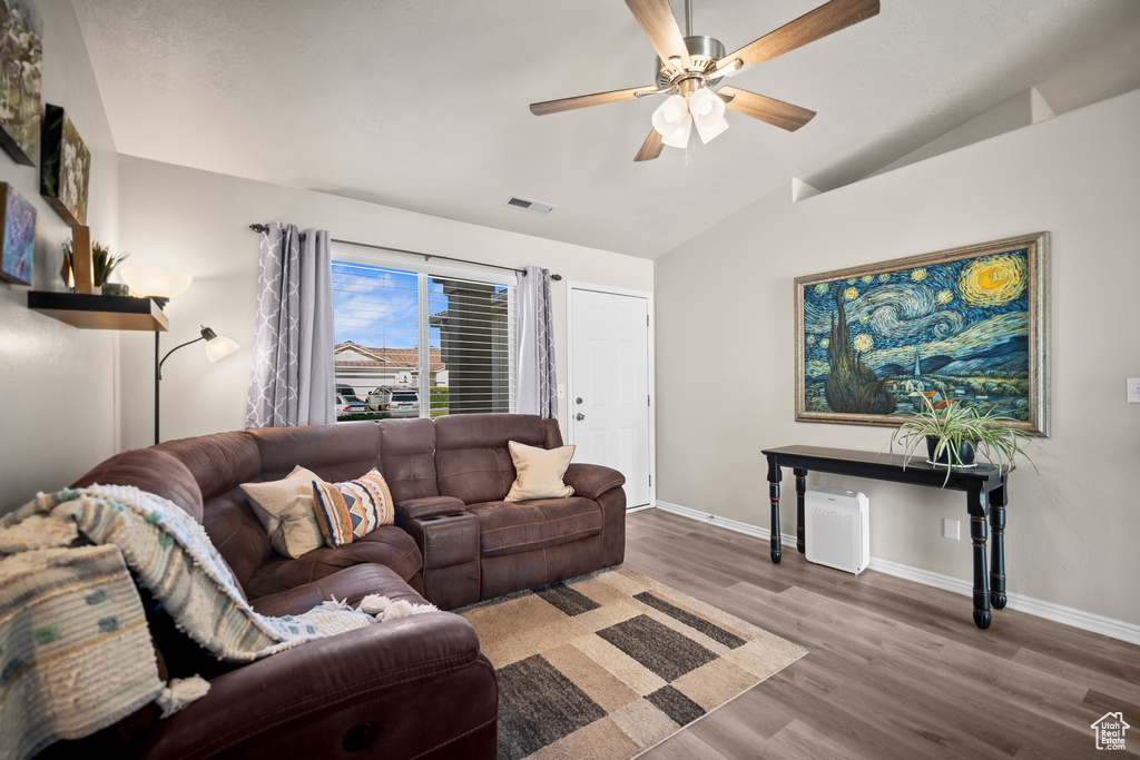 Living area with lofted ceiling, wood finished floors, and ceiling fan
