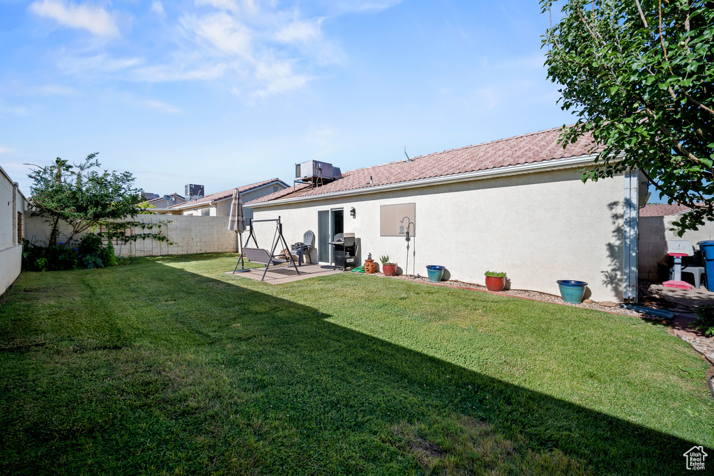 Rear view of house featuring a fenced backyard, stucco siding, and a patio
