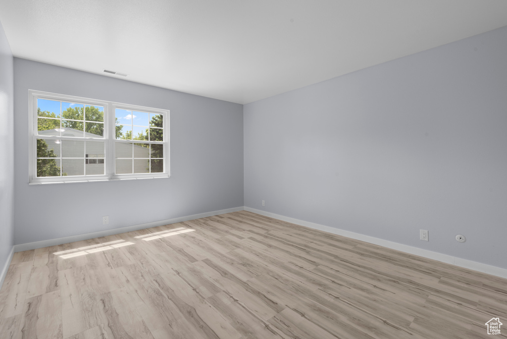 Spare room featuring wood finished floors and baseboards