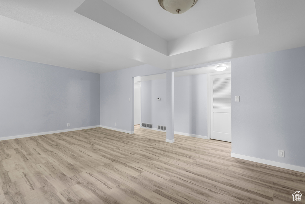 Spare room featuring light wood-style floors and a tray ceiling