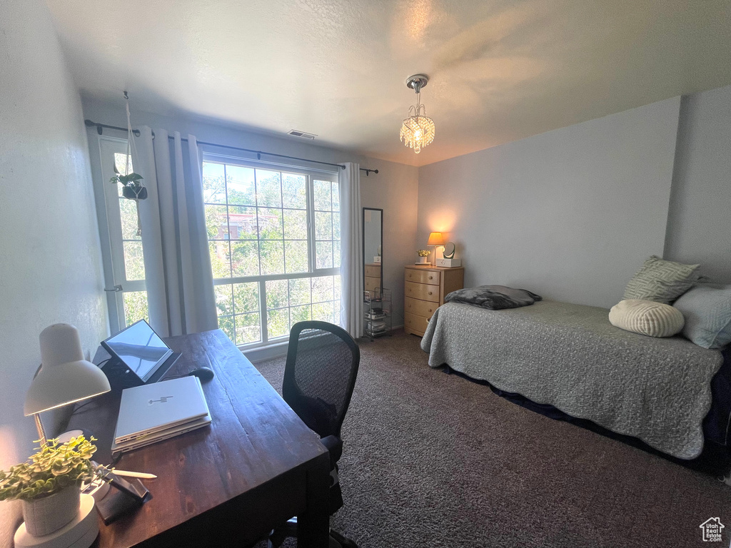 Carpeted bedroom with a desk