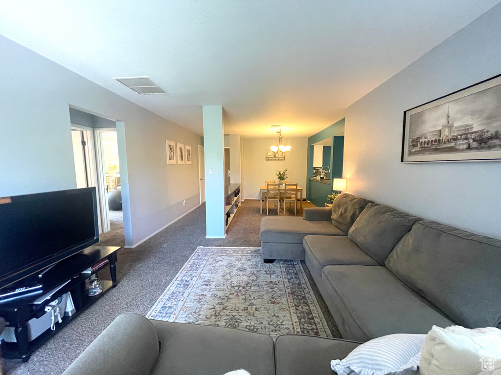 Carpeted living room featuring a chandelier