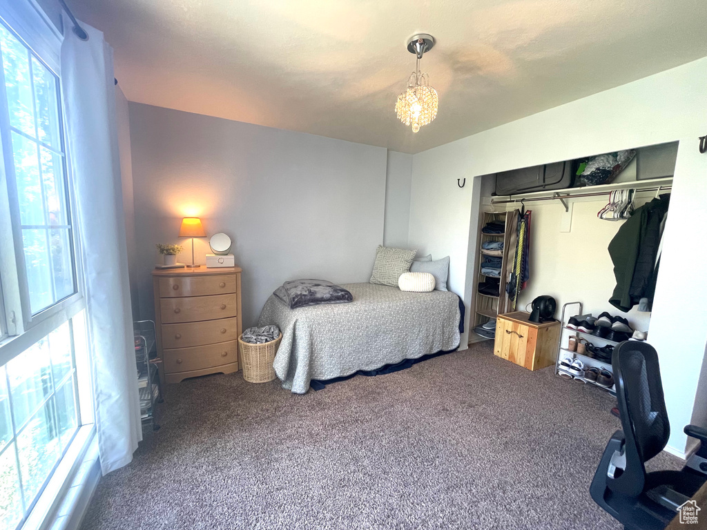Bedroom with multiple windows, carpet floors, a chandelier, and a closet