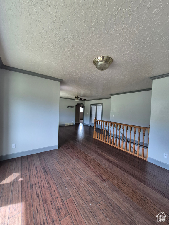 Unfurnished room with a ceiling fan, hardwood / wood-style floors, a textured ceiling, and crown molding
