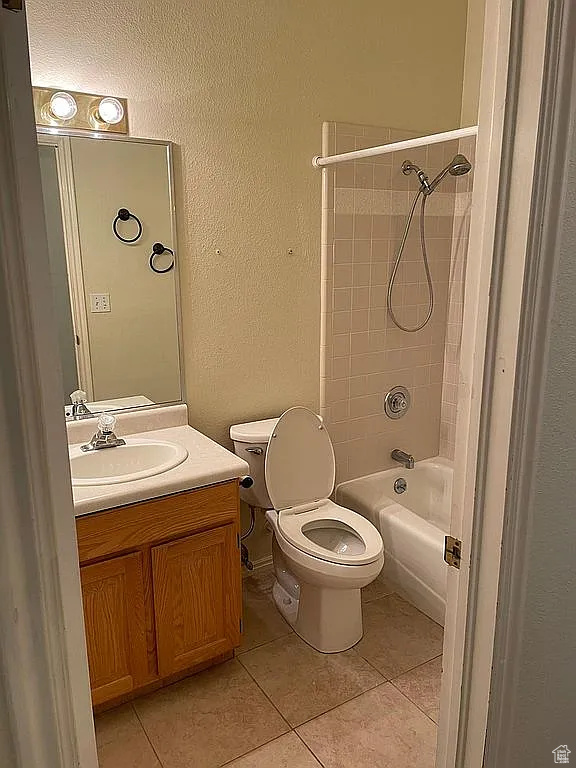 Full bathroom featuring tile patterned floors, vanity, bathtub / shower combination, and a textured wall