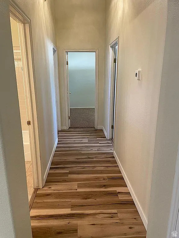 Hall with wood finished floors and baseboards