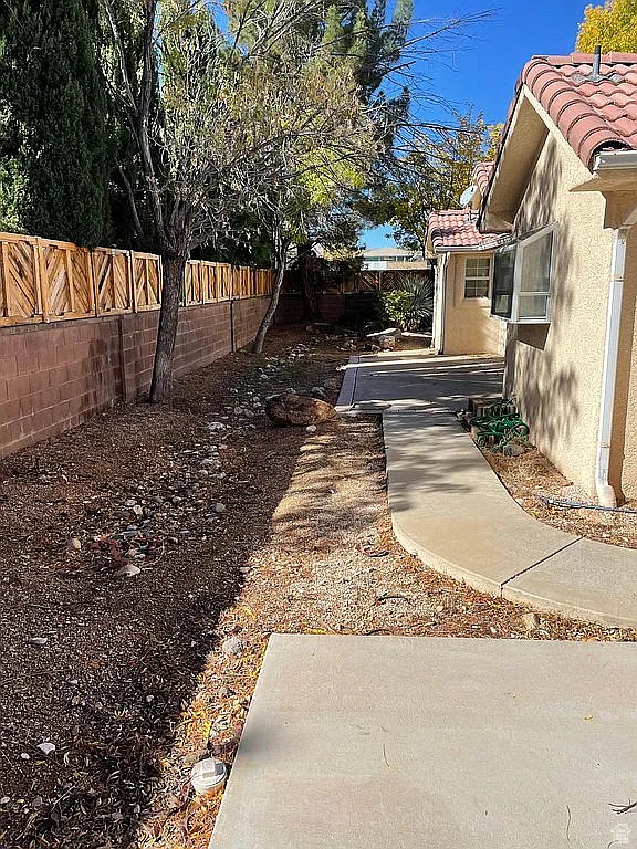 Fenced backyard with a patio and cooling unit