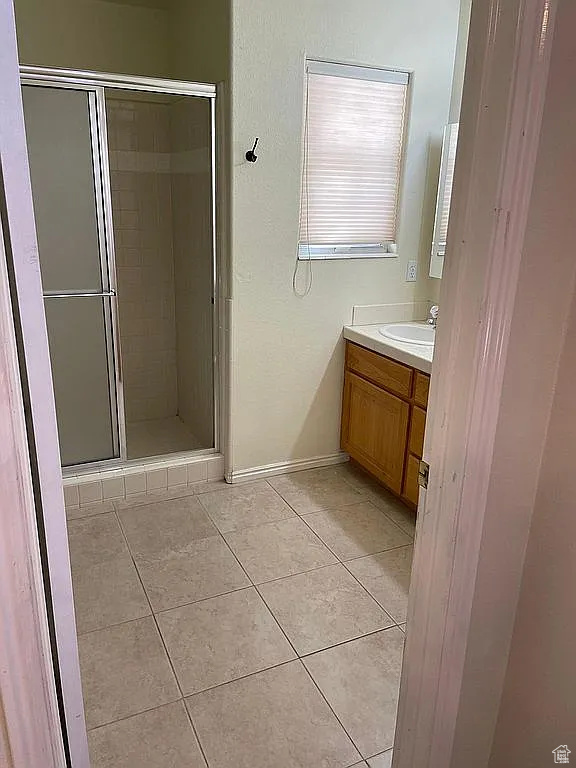 Bathroom with tile patterned floors, vanity, and a stall shower