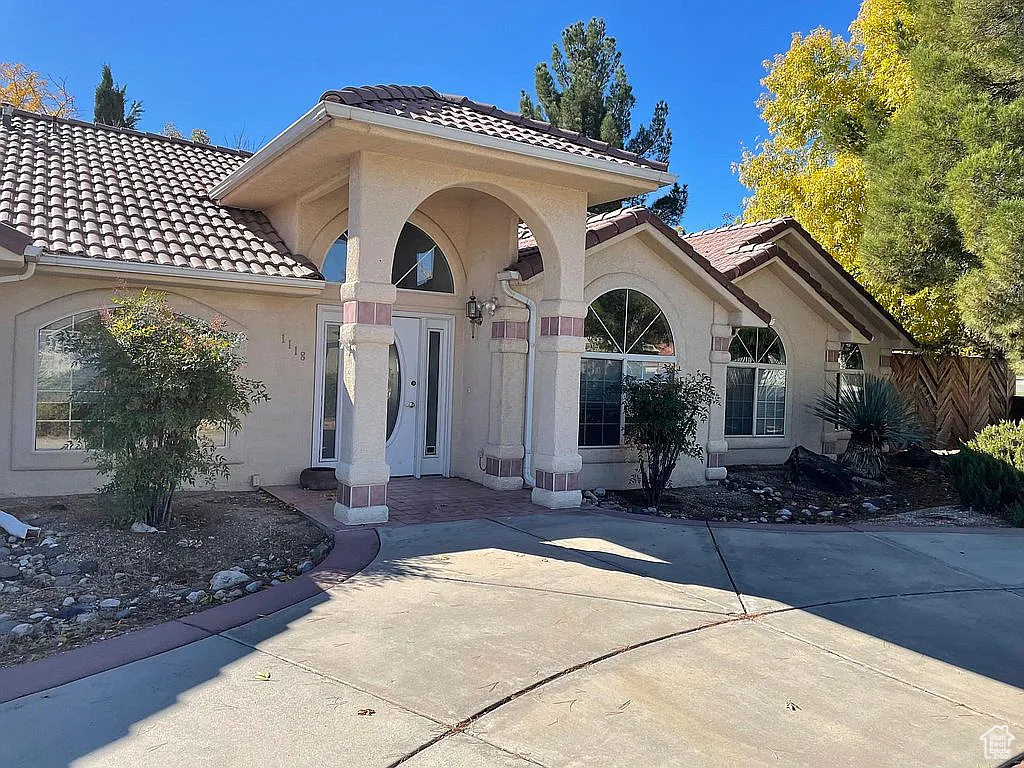 Property entrance with a tiled roof and stucco siding