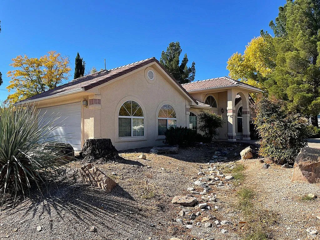 View of front of home with a garage and stucco siding