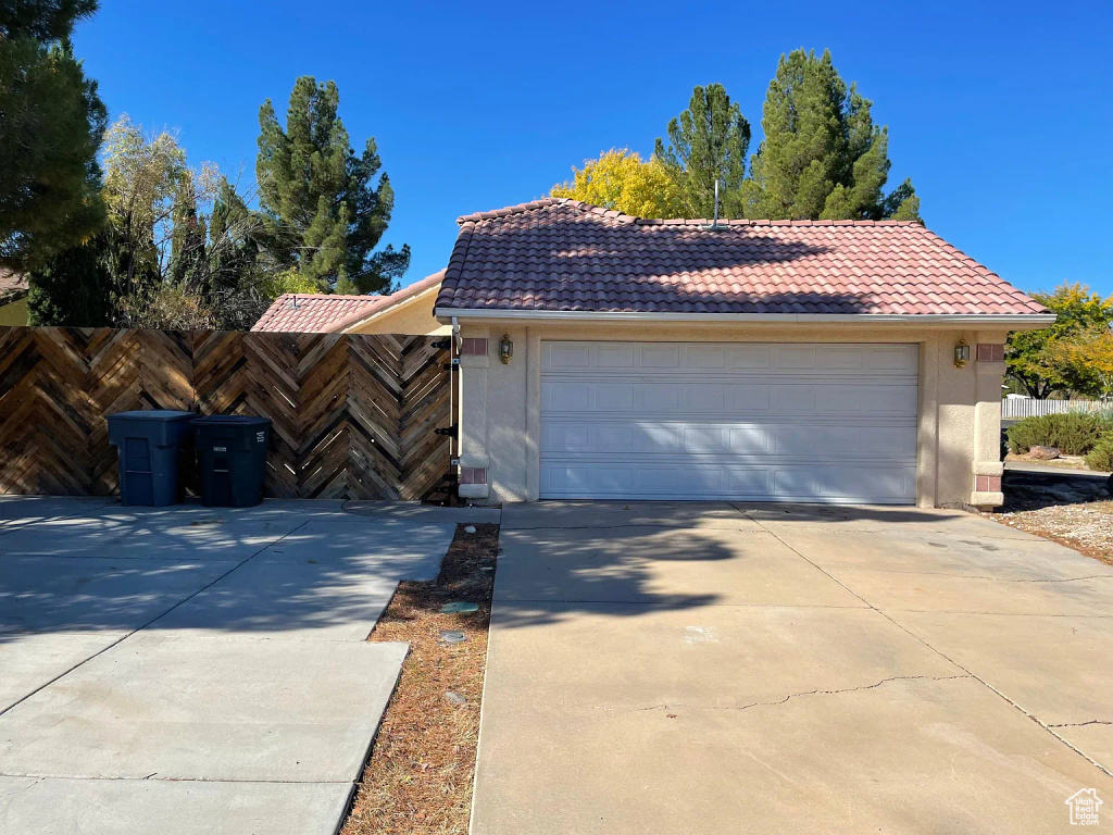 View of front of home with a tiled roof, stucco siding, and driveway