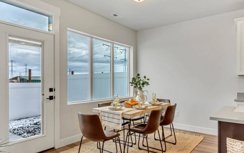 Dining space with light wood-style flooring and baseboards