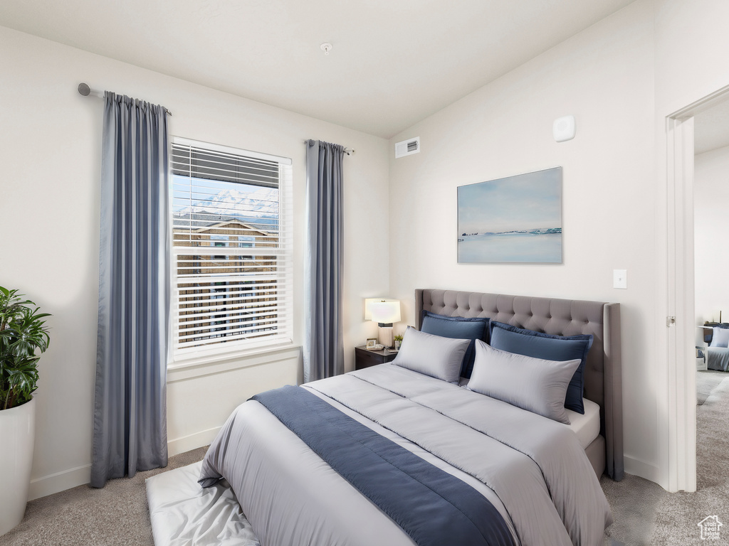 Bedroom featuring light colored carpet and baseboards