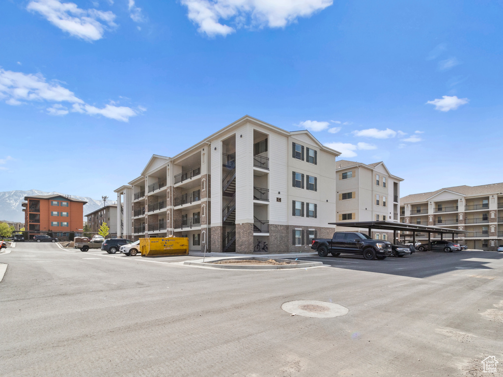 View of building exterior with covered and uncovered parking