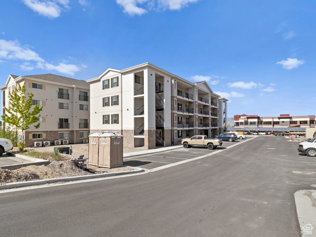View of apartment building / complex featuring uncovered parking