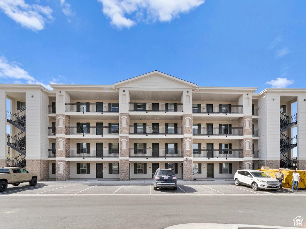 View of apartment building / complex with uncovered parking