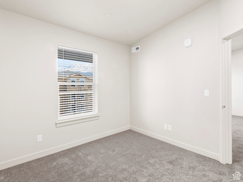 Carpeted spare room with baseboards