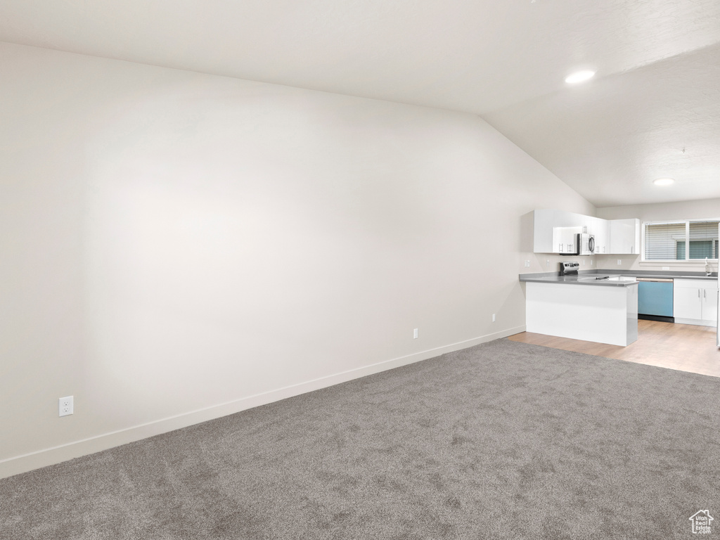 Unfurnished living room with light carpet, lofted ceiling, and recessed lighting