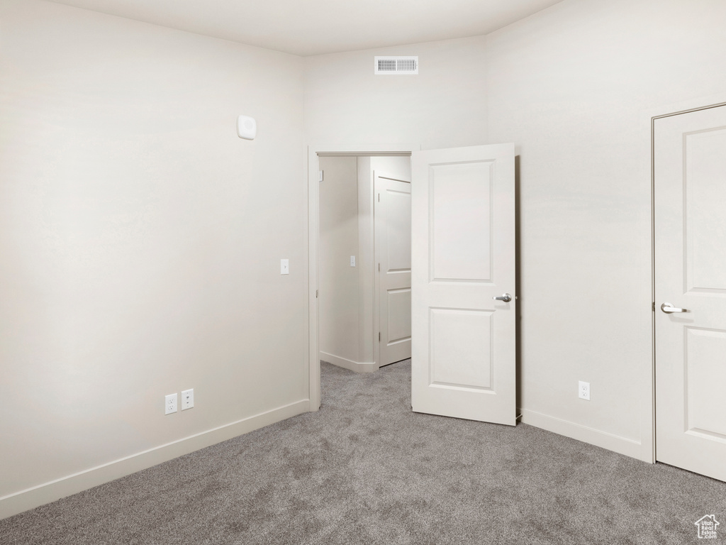 Unfurnished bedroom with carpet flooring and baseboards