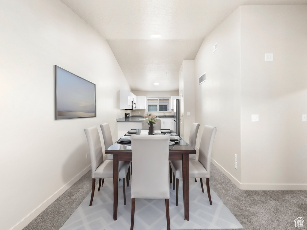 Dining space featuring light carpet and baseboards
