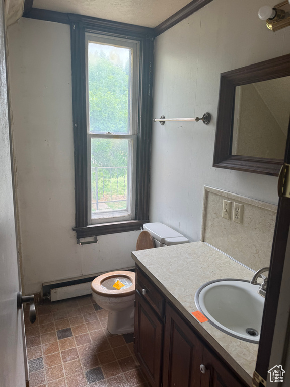 Half bathroom with vanity and a baseboard radiator