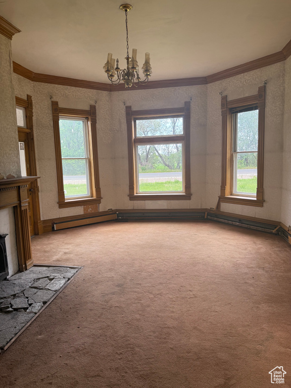 Unfurnished living room featuring crown molding, a chandelier, and carpet