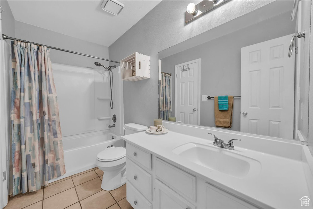 Bathroom featuring shower / bath combination with curtain, vanity, and tile patterned flooring