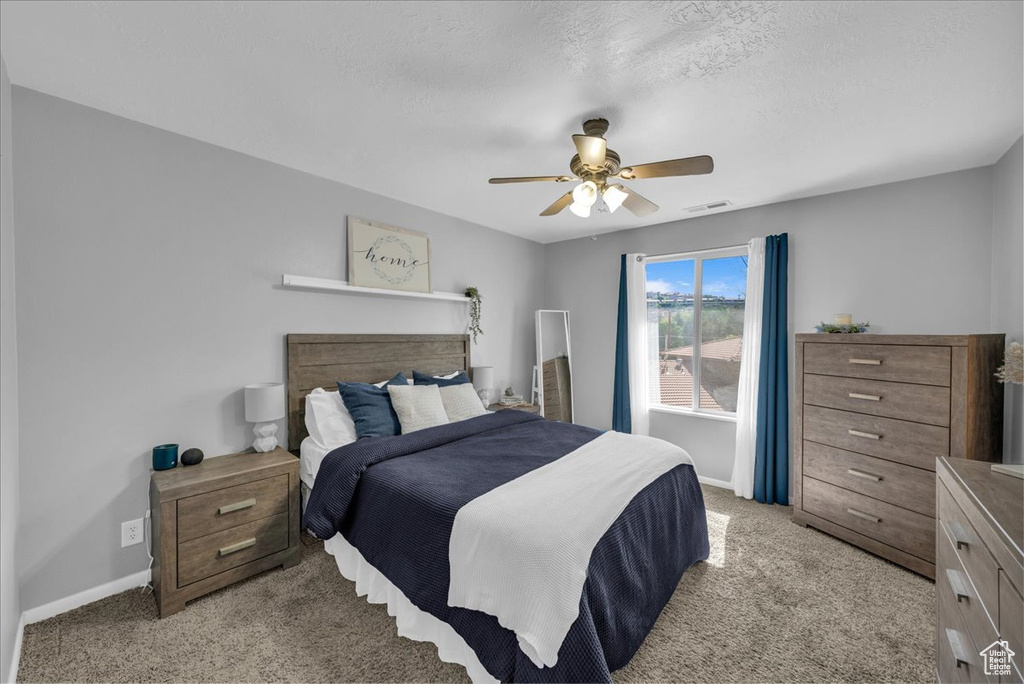 Bedroom with light carpet and a ceiling fan