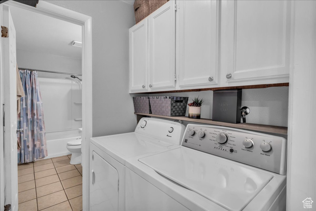 Laundry room featuring washer and clothes dryer and light tile patterned floors