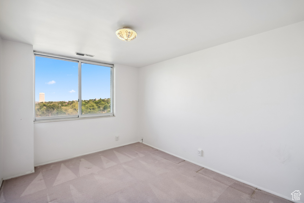 Spare room featuring light carpet and baseboards