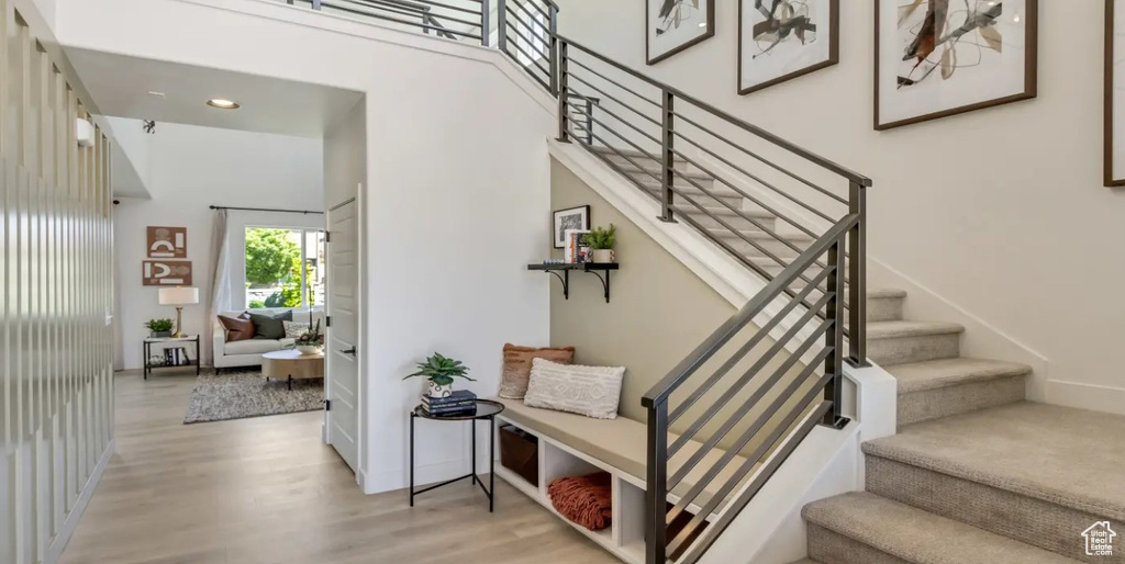 Stairway featuring wood finished floors and recessed lighting