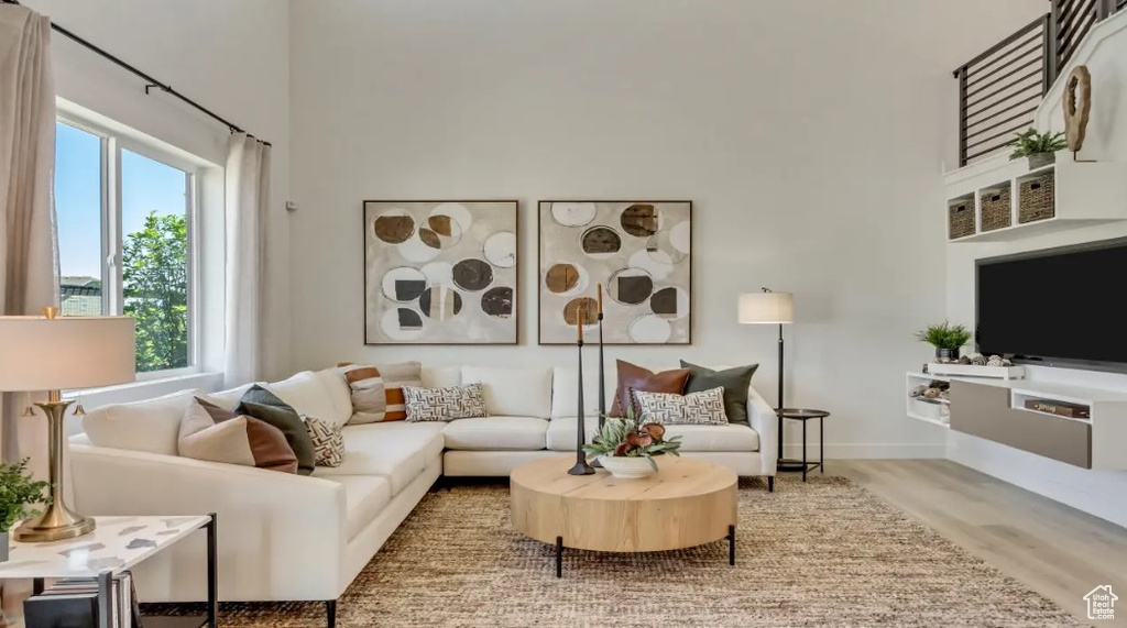 Living room featuring a towering ceiling and wood finished floors