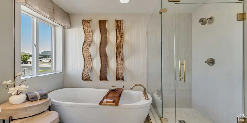 Full bath featuring a shower stall and a freestanding bath