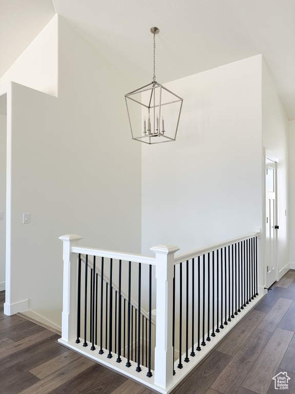 Corridor featuring an upstairs landing, a chandelier, and wood finished floors