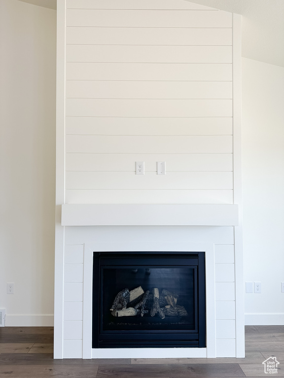 Detailed view of a glass covered fireplace and wood finished floors