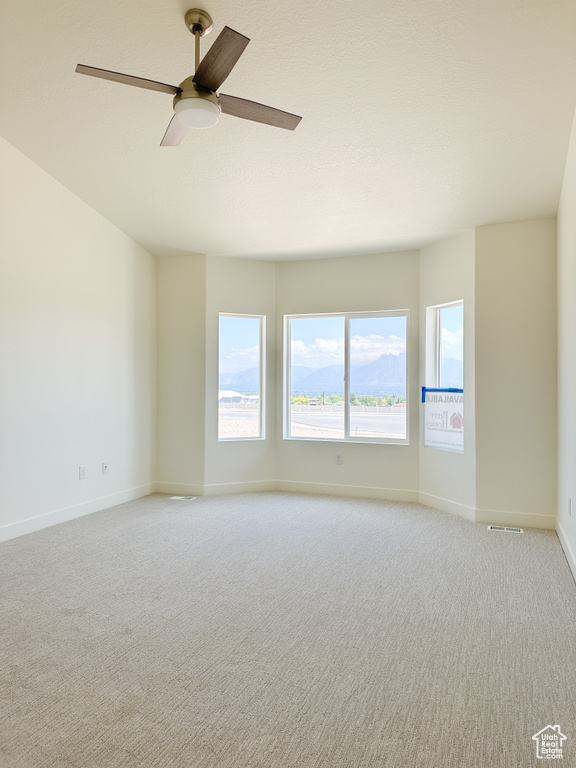 Unfurnished room with light colored carpet and ceiling fan