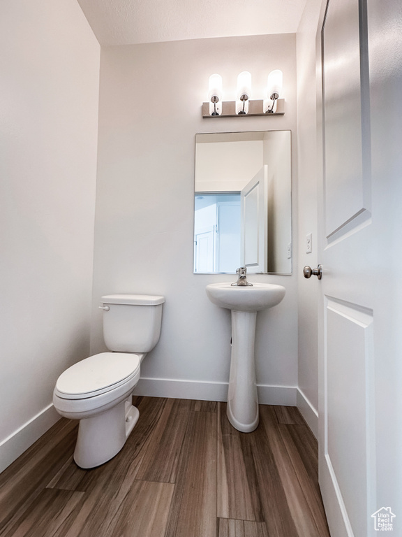 Bathroom featuring toilet and wood finished floors
