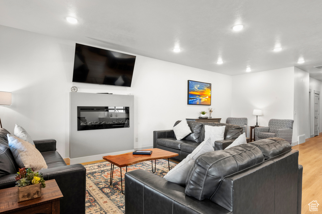 Living room with light wood-style floors and recessed lighting