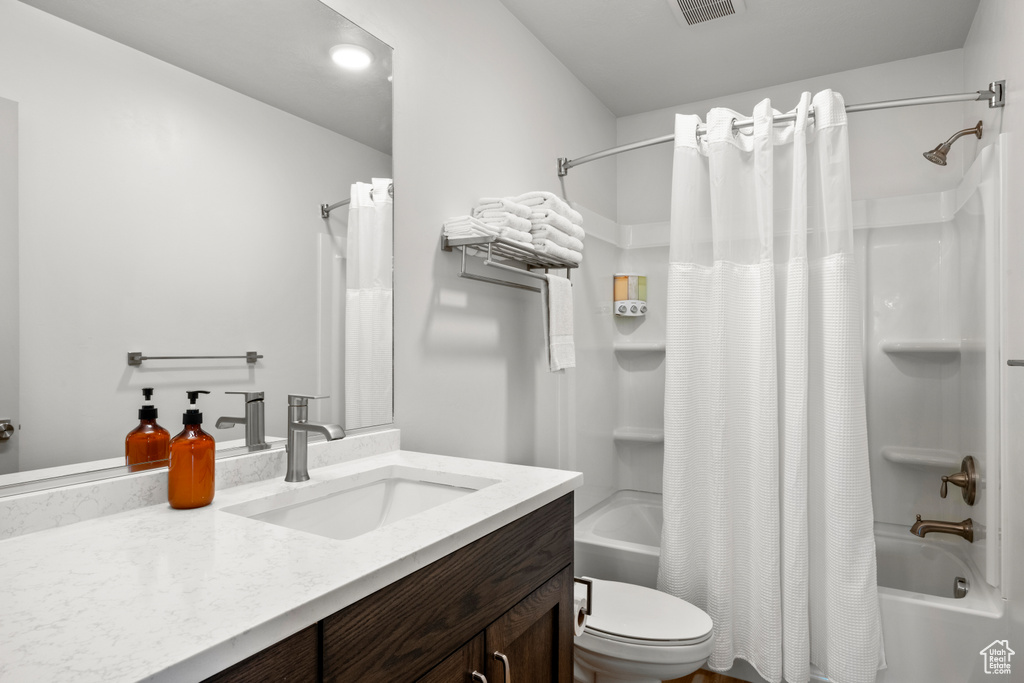 Bathroom featuring vanity and shower / bathtub combination with curtain