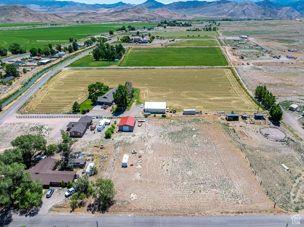 Aerial view of sparsely populated area featuring a mountainous background and rows of crops